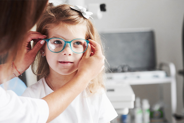 Kid trying on glasses in optical boutique